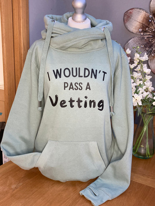 A green cross neck hood with hood and front pocket and slogan printed on the front saying I wouldn't pass a vetting 