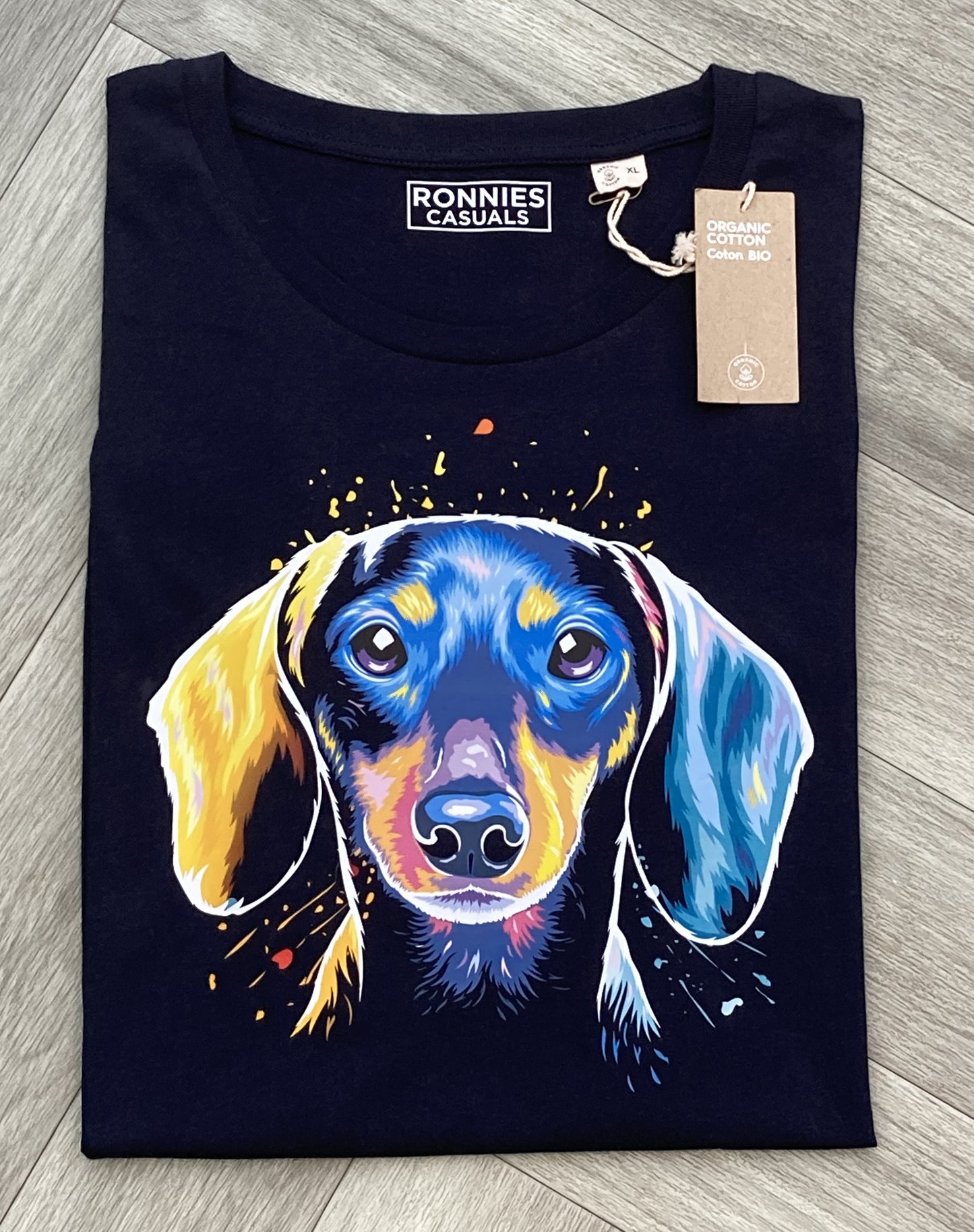 Colourful Dachshund dog head in very bright colours printed on a navy Blue t-shirt