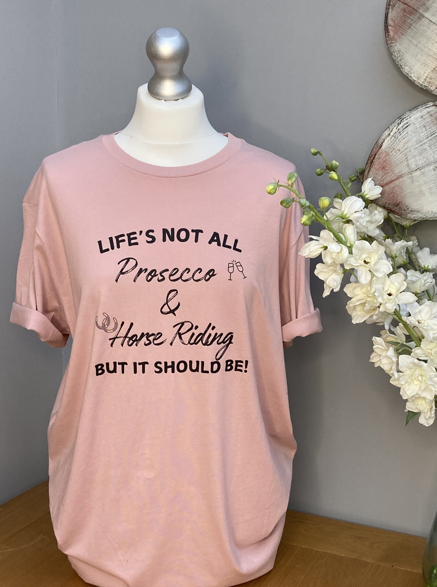 Pink T-shirt printed with the words "Life's not all Prosecco & Horse Riding, but it should be"